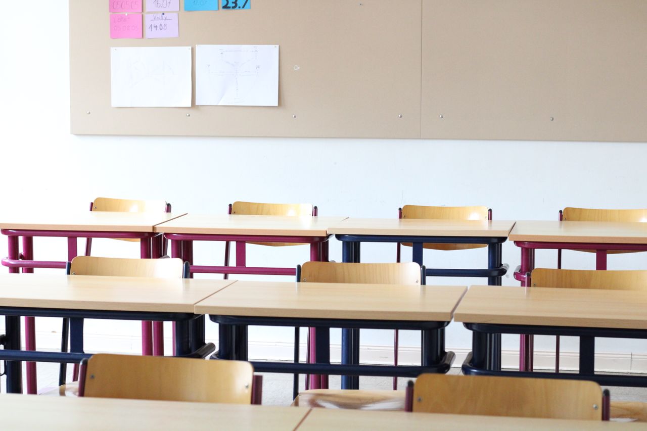 ours-journey A bright, empty classroom in Einbeck, Deutschland, featuring wooden desks and chairs.