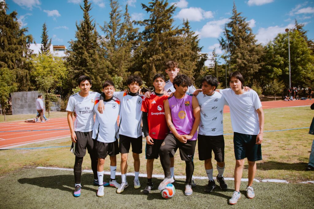 pexels photo 35481336 35481336 Group of teenagers posing together at a soccer field on a sunny day, showcasing team spirit and friendship.