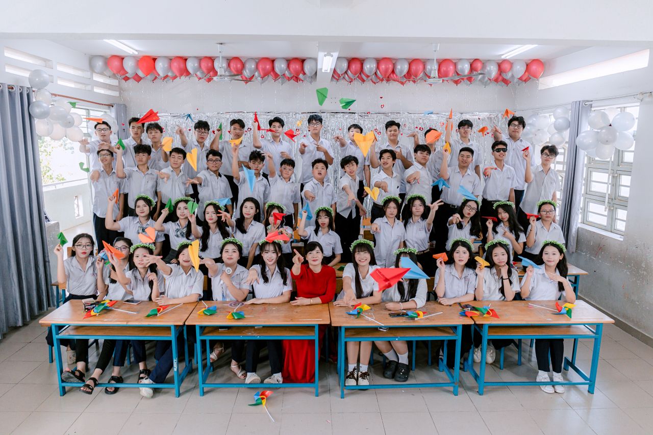 services-04 Group of students celebrating indoors with balloons and paper planes.