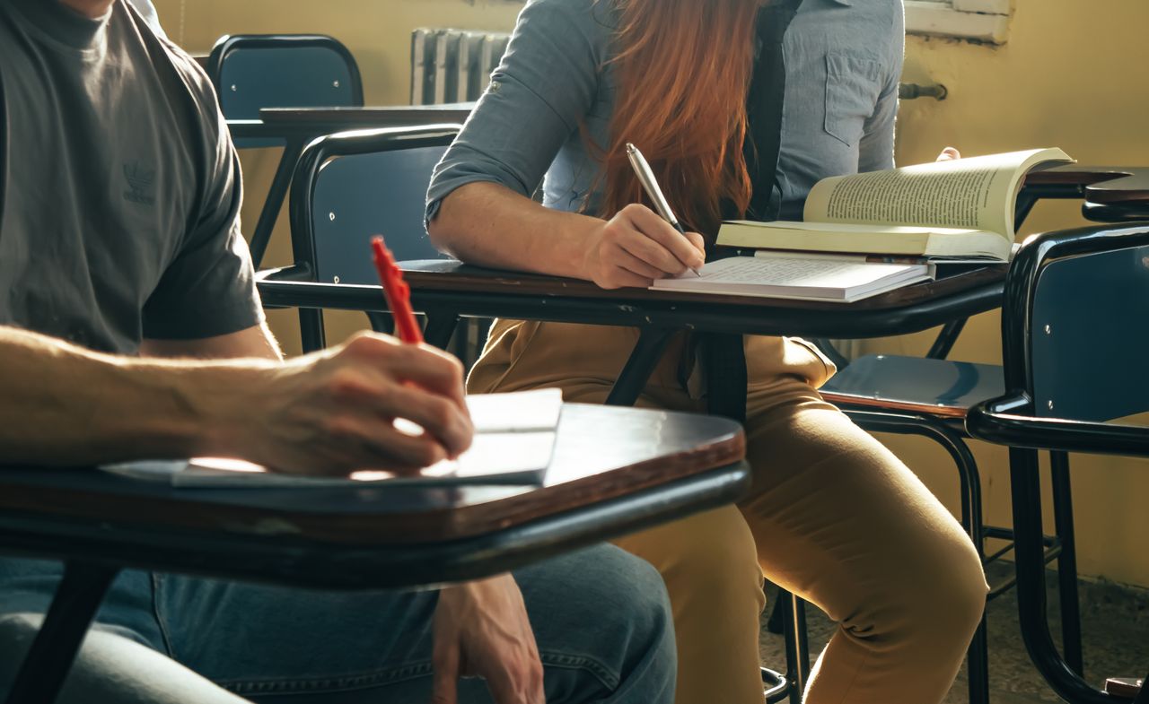 Crafting Captivating Headlines: Your awesome post title goes here Two students writing notes in a classroom setting, focusing on study and education
